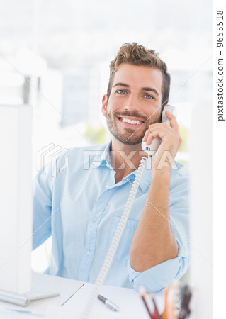 Smiling young man using phone and computer Smiling young man using phone and computer 9655518