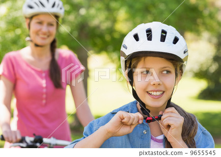 Smiling woman with her daughter riding a bicycle 9655545
