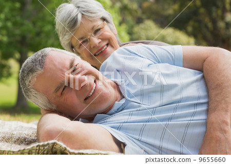 Close-up portrait of a senior couple lying at park 9655660