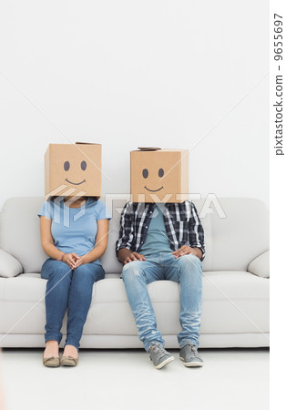 Young couple with happy smiley boxes over faces 9655697