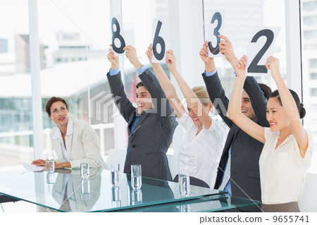 Judges in a row holding score signs 9655741