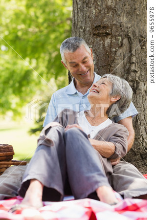 Happy relaxed senior couple sitting at park 9655978