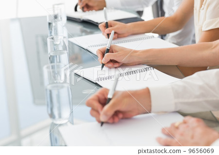 Business people taking down notes at a meeting Business people taking down notes at a meeting 9656069