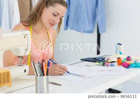 Female fashion designer working on her designs Female fashion designer working on her designs 9656111