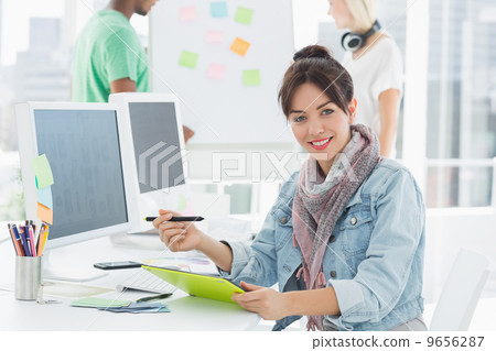 Artist drawing something on graphic tablet with colleagues behin Artist drawing something on graphic tablet with colleagues behin 9656287