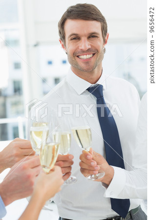 Businessman toasting with champagne in office 9656472