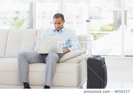 Businessman using laptop waiting to depart on business trip 9656557