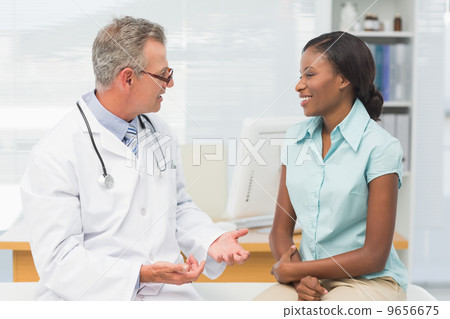 Doctor speaking with cheerful young patient 9656675
