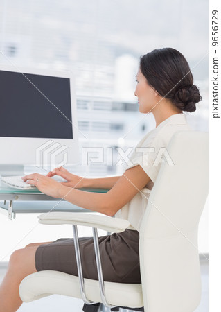 Young businesswoman using computer in office 9656729