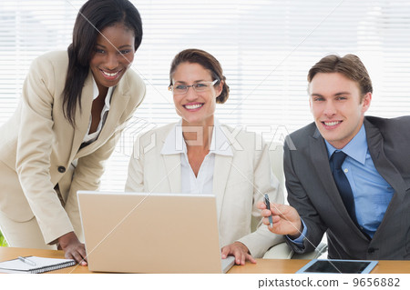 Smiling business colleagues with laptop in meeting Smiling business colleagues with laptop in meeting 9656882