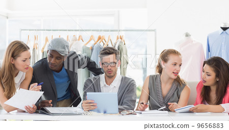 Fashion designers discussing designs Fashion designers discussing designs 9656883