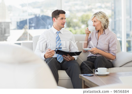 Smart businessman and his secretary with diary and tea cup 9656884