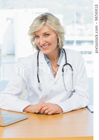 Female doctor sitting at desk in medical office 9656918