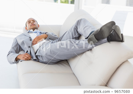 Businessman napping on the couch Businessman napping on the couch 9657080