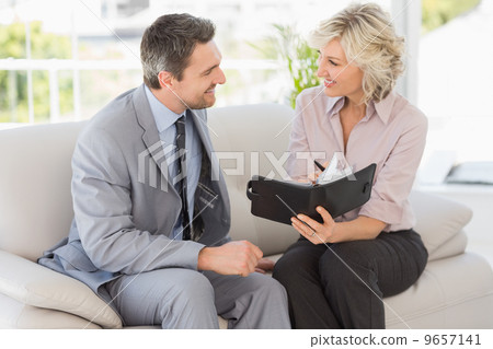 Businessman and his secretary with diary at home Businessman and his secretary with diary at home 9657141