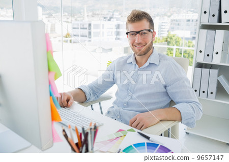 Portrait of a smiling young man using computer 9657147