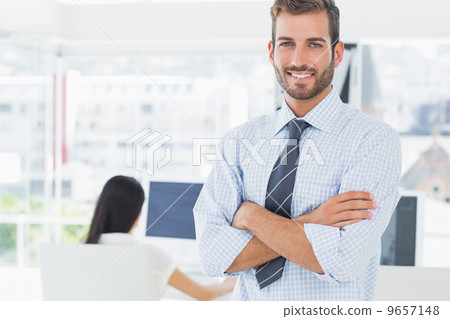 Portrait of a casual male artist with colleague in background Portrait of a casual male artist with colleague in background 9657148