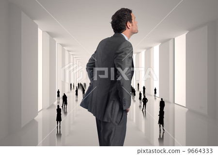 Composite image of serious businessman with hands on hips Composite image of serious businessman with hands on hips 9664333