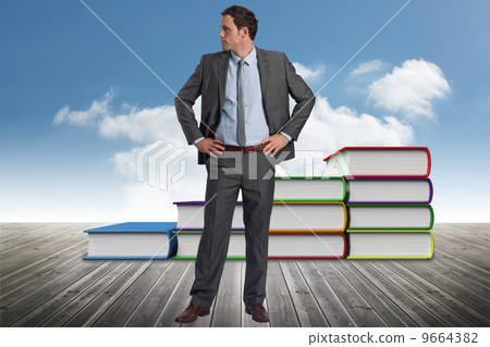 Composite image of serious businessman with hands on hips Composite image of serious businessman with hands on hips 9664382