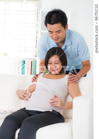 chinese husband listening to his wife's stomach chinese husband listening to his wife's stomach 9670210