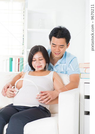 chinese pregnant father and mother with headphone 9670211