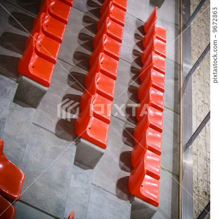 Closeup of red sport stadium seats. Empty stand. Team sport supporter 9672863
