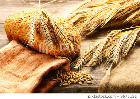 Rye spikelets and bread still life on wooden background 9675181