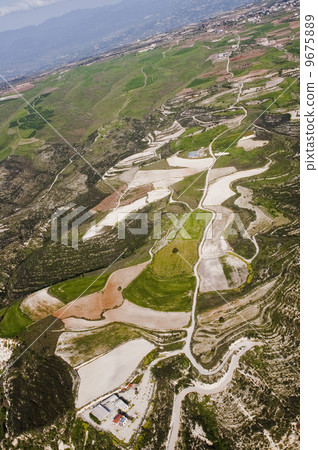 Aerial view at farm fields in front of misty mountains Aerial view at farm fields in front of misty mountains 9675889