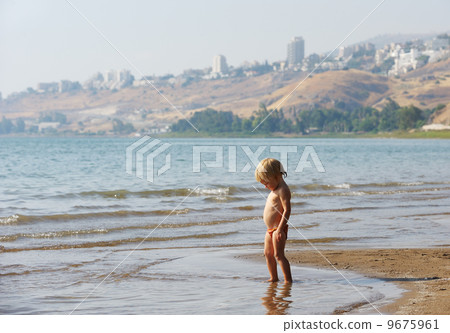 Child on the shore of lake Kinneret in the morning 9675961