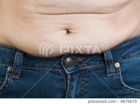 Woman pinching fat from her abdomen 9678679