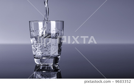 water splashing from glass on blue background water splashing from glass on blue background 9683352