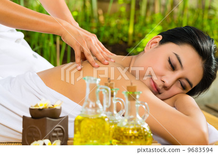 Asian woman having a massage in tropical setting Asian woman having a massage in tropical setting 9683594