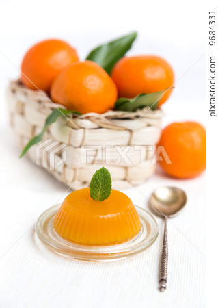 jelly and fresh orange mandarins with leafs in basket 9684331