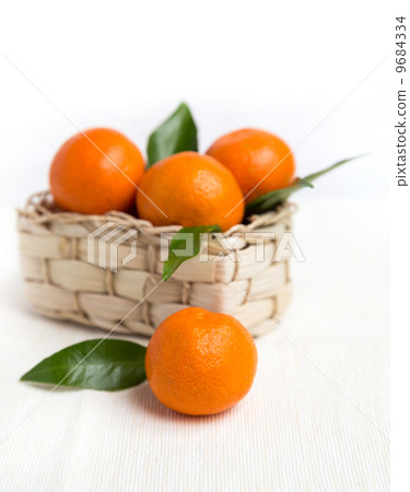 fresh orange mandarins with leafs in basket 9684334