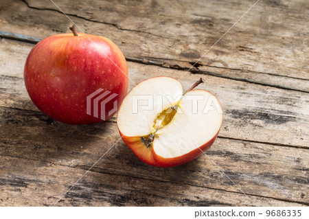 Whole and Cut in Half Apple lying on Textured Weathered Wooden Table Whole and Cut in Half Apple lying on Textured Weathered Wooden Table 9686335