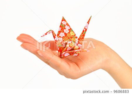 A woman's hand with folding cranes. 9686883