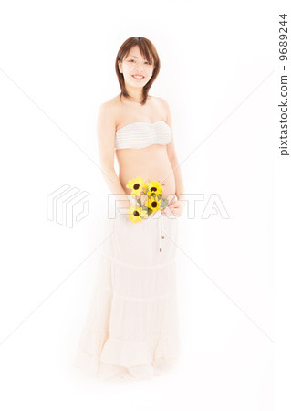 Young pregnant wearing cute maternity dress with bouquet in hand Young pregnant wearing cute maternity dress with bouquet in hand 9689244