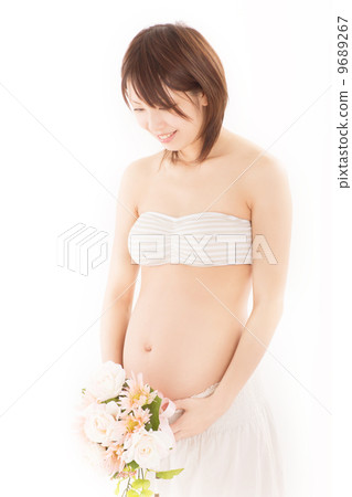 一件孕婦禮服的一名年輕孕婦與她俏麗的花束 一件孕婦禮服的一名年輕孕婦與她俏麗的花束 9689267