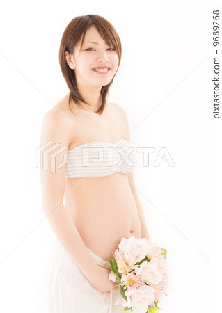一件孕婦禮服的一名年輕孕婦與她俏麗的花束 一件孕婦禮服的一名年輕孕婦與她俏麗的花束 9689268