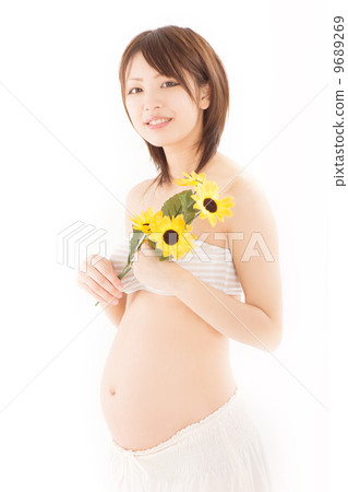 A young pregnant woman in a maternity dress with her pretty bouquet A young pregnant woman in a maternity dress with her pretty bouquet 9689269