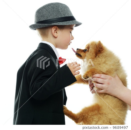 Little boy in hat and black suit with little spitz 9689497