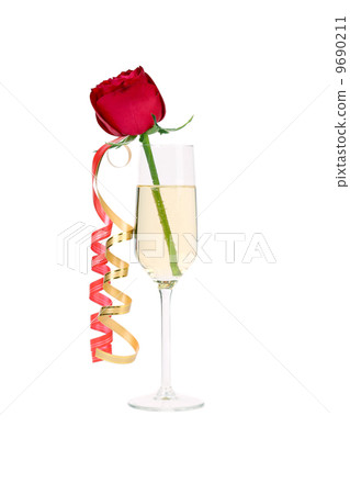 Red rose in glass of champagne and paper streamer. Red rose in glass of champagne and paper streamer. 9690211