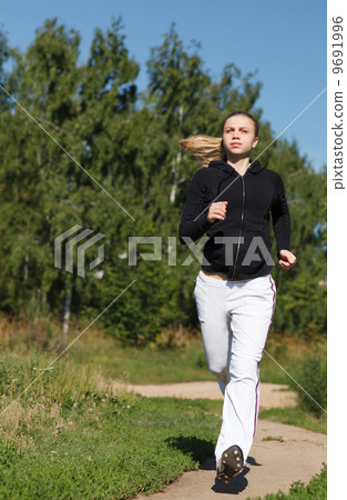 Girl running in the park. Wide shot 9691996