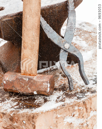 blacksmith anvil, tongs and hammer in old smithy 9693053