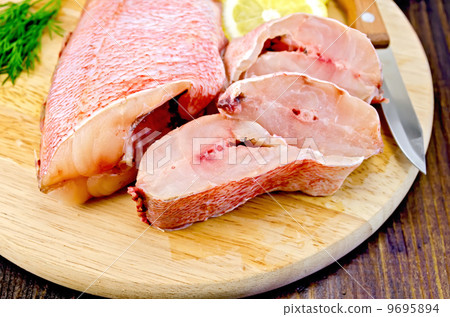 Fillet of sea bass with dill on board 9695894