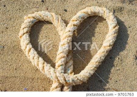 rope with a heart knot - sand background rope with a heart knot - sand background 9701763