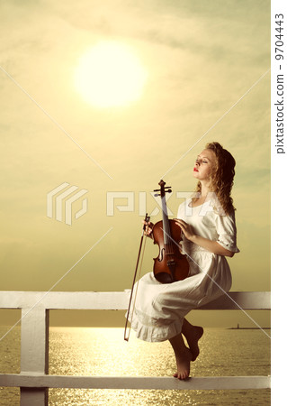 The blonde girl with a violin outdoor The blonde girl with a violin outdoor 9704443