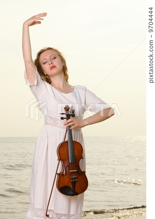 The blonde girl with a violin outdoor The blonde girl with a violin outdoor 9704444