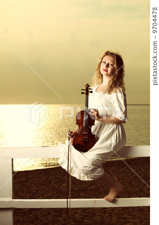 The blonde girl with a violin outdoor 9704478