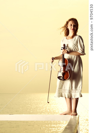 The blonde girl with a violin outdoor The blonde girl with a violin outdoor 9704530